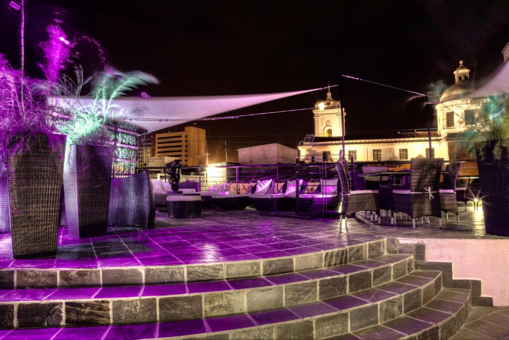 een podium met paarse lichten voor een gebouw bij Casa de Leda, a Kali Hotel in Santa Marta