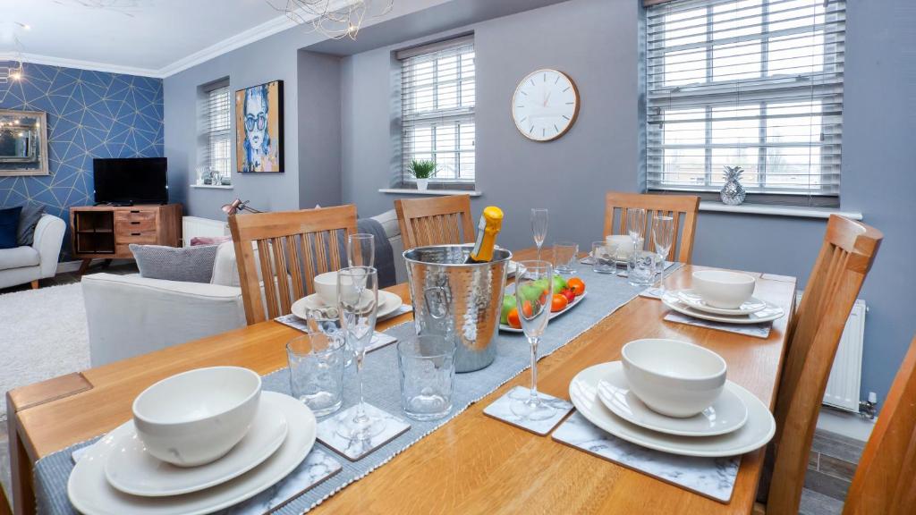 a dining room with a table with plates and glasses at The Station Apartment- A Stunning Space, Close To The City Centre in York