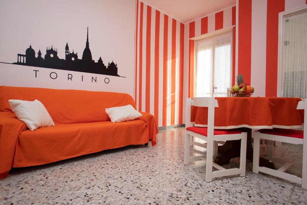 uma sala de estar com um sofá laranja e uma mesa em Spezia em Turim