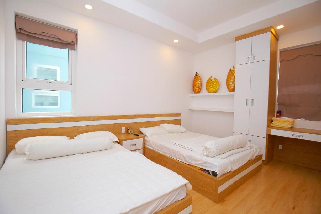 une chambre avec deux lits et une fenêtre dans l'établissement Căn hộ Nghỉ Dưỡng Aparment Melody Vũng Tàu - Tomorrow Homestay 1, à Vung Tau