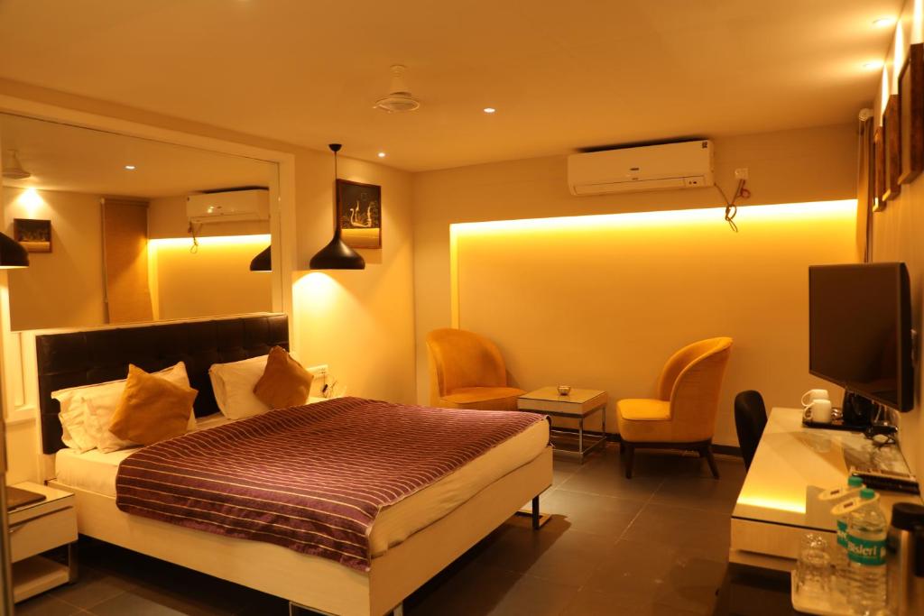 a hotel room with a bed and a desk at Hotel KC Palace in Bhopal