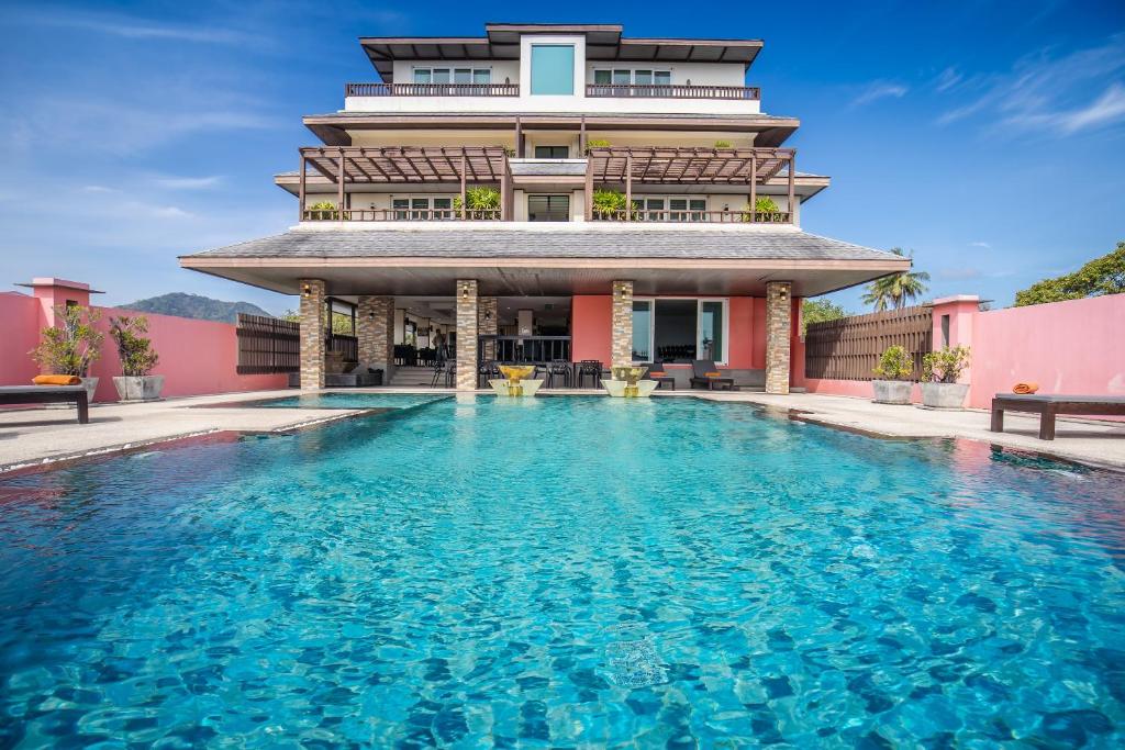 una casa con piscina frente a un edificio en Ratana Hotel Chalong, en Rawai Beach