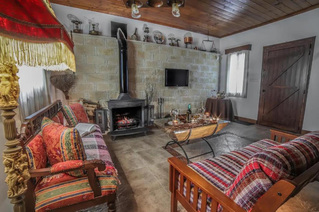 ein Wohnzimmer mit 2 Sofas und einem Kamin in der Unterkunft Lofou Traditional House in Lofou