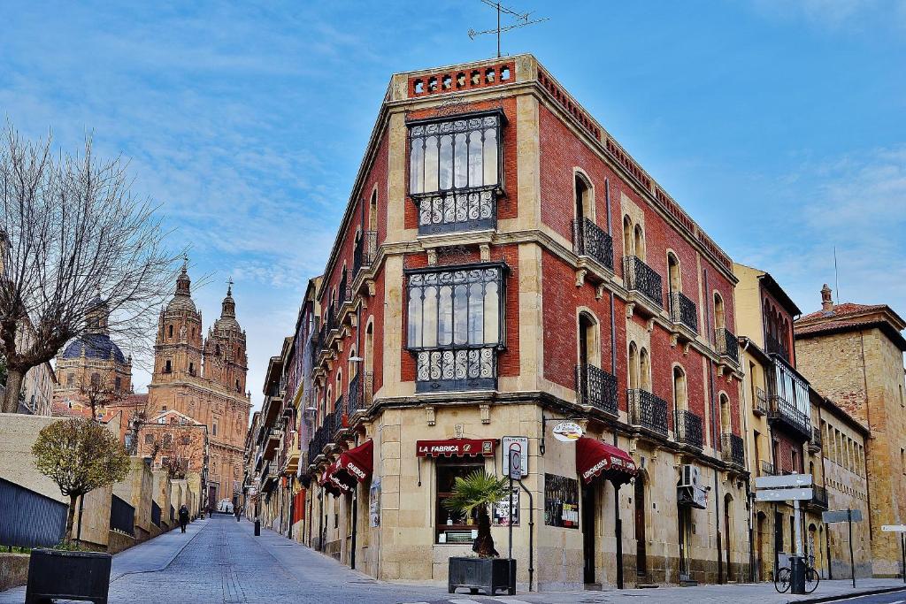 un edificio alto de ladrillo con ventanas en una calle en MoneoHeritage, en Salamanca