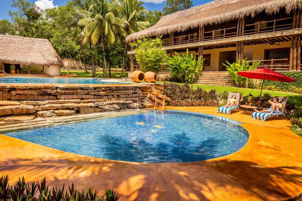 a swimming pool in front of a house at The Lodge At Uxmal in Uxmal