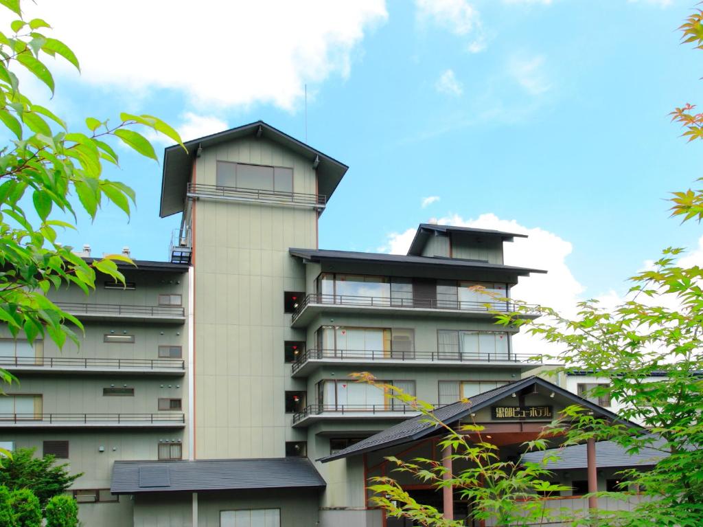 um edifício de apartamentos alto com um telhado em Kurobe View Hotel em Omachi