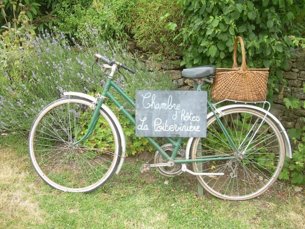 Una bicicleta estacionada junto a un cartel en el césped en La Poitevinière, en Sainte-Hermine