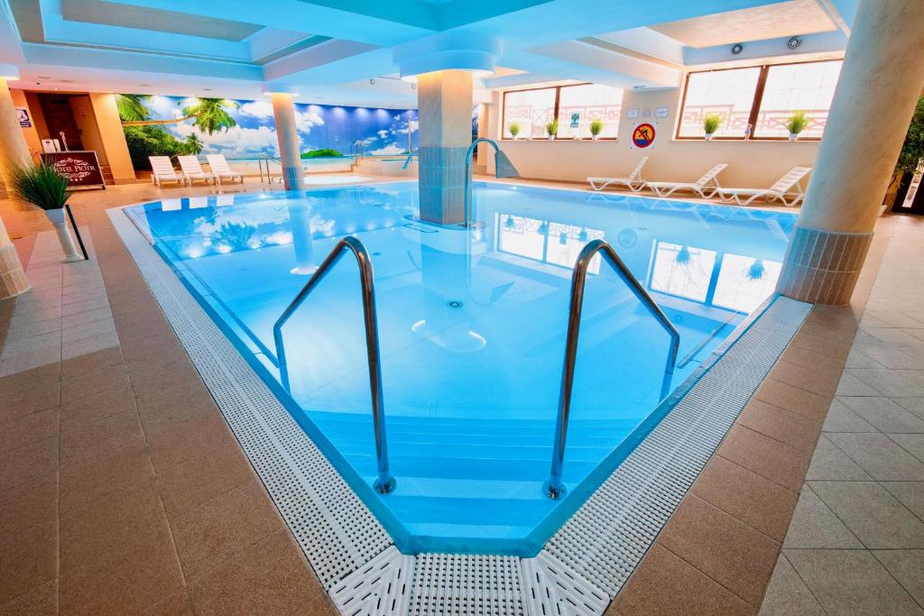 a large swimming pool in a hotel room at Hotel Piotr Spa&Wellness in Boguszów-Gorce