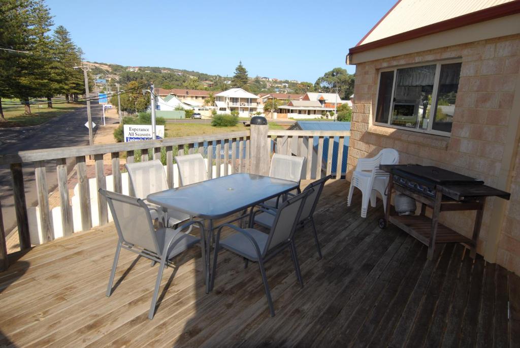 a table and chairs on a deck with a piano at Esperance Foreshore Apartments in Esperance