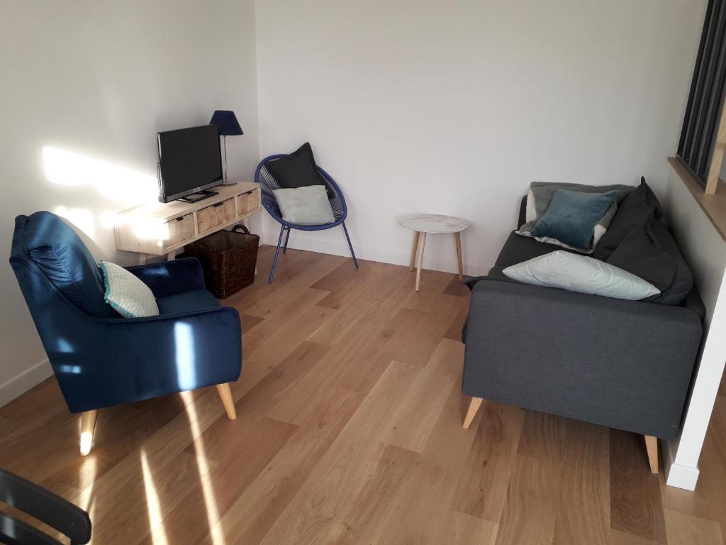 - un salon avec deux chaises et une télévision dans l'établissement Appartement au coeur de Bayonne sur les remparts, à Bayonne