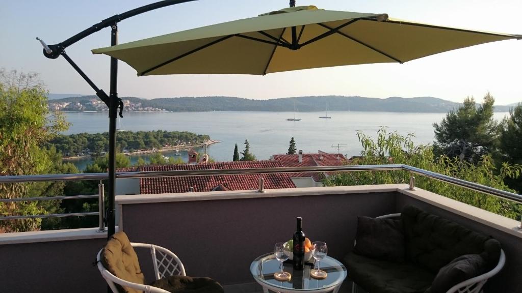 een patio met een tafel en een parasol op een balkon bij Apartmani Ferdi in Trogir