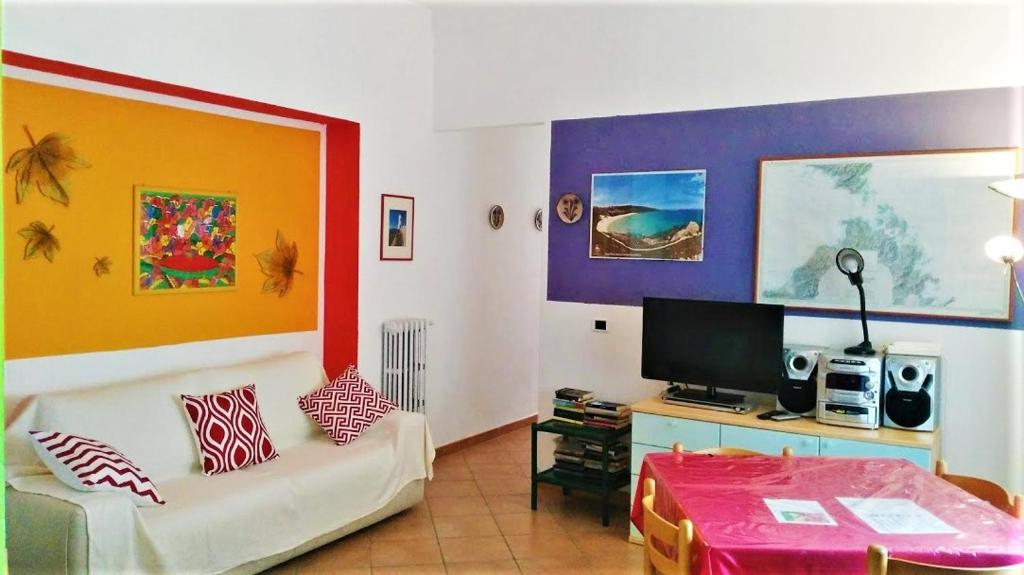 uma sala de estar com um sofá e uma televisão em La Corte Appartamenti em Santa Teresa Gallura