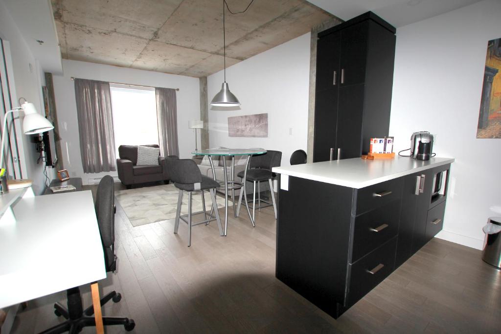 cocina y sala de estar con mesa y sillas en Condo "Imagine" - stationnement privé inclus, en Quebec