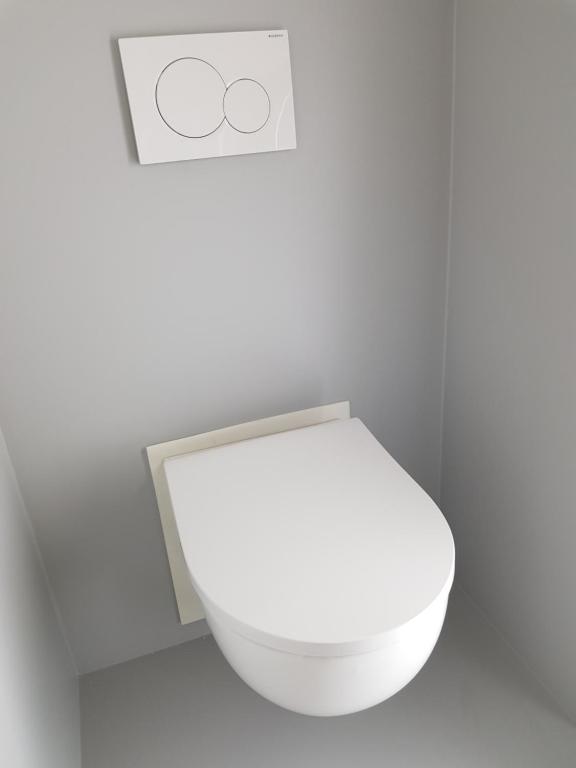a bathroom with a white toilet with a sign above it at B&B The Project in Heerlen
