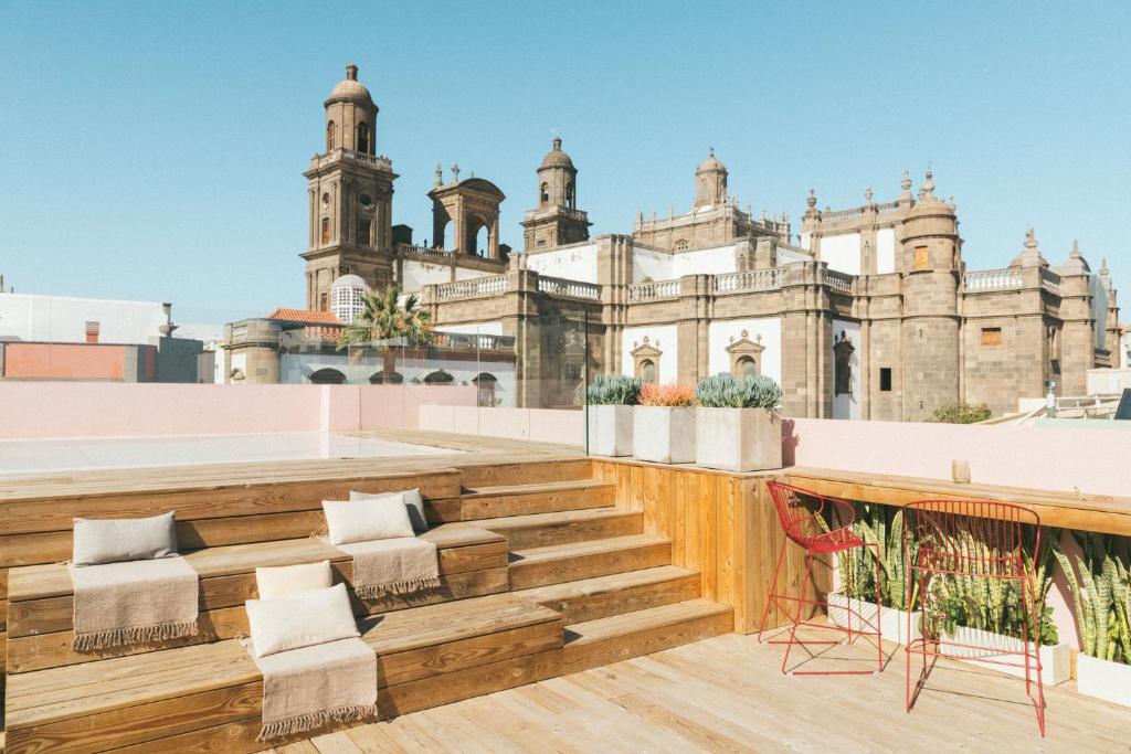 uma vista do telhado de um edifício com cadeiras em VEINTIUNO Emblematic Hotels - Adults Only em Las Palmas de Gran Canárias