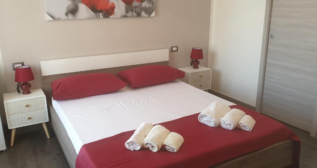 - une chambre avec un lit blanc et des oreillers rouges dans l'établissement T-Room, à Tropea