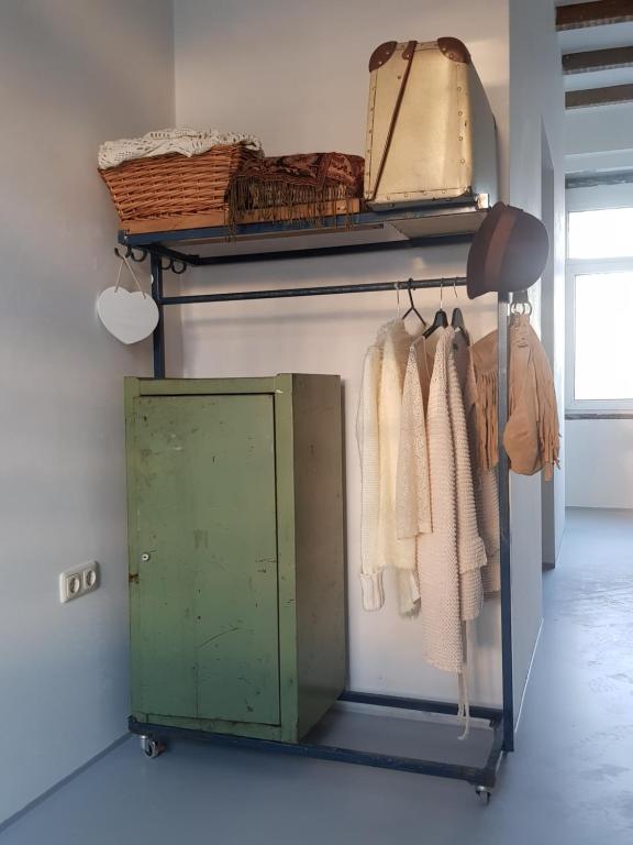 a closet with a green door and a rack of clothes at B&B The Project in Heerlen