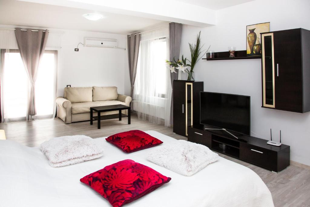 a bedroom with a bed with red pillows on it at Alex Residence in Otopeni