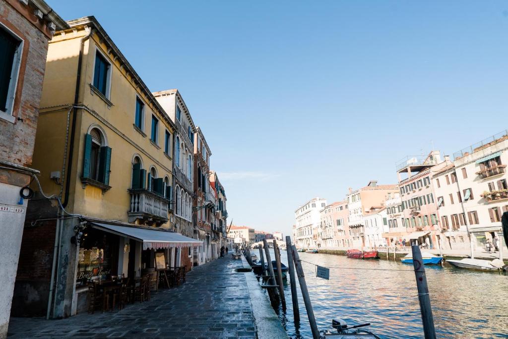 eine Kopfsteinpflasterstraße mit Gebäuden und einem Kanal in der Unterkunft Casa Agostina in Venedig