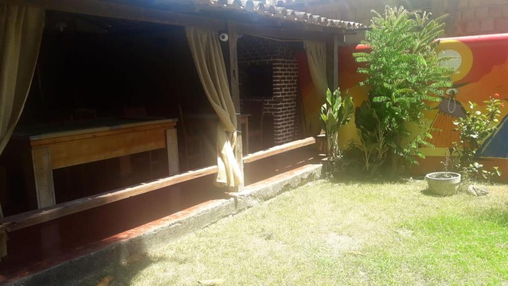 una casa con una ventana y una planta en el patio en Cantinho dos Aquários, en Arraial d'Ajuda