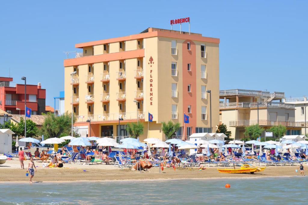 a crowd of people on a beach with a hotel at Hotel Florence in Marotta