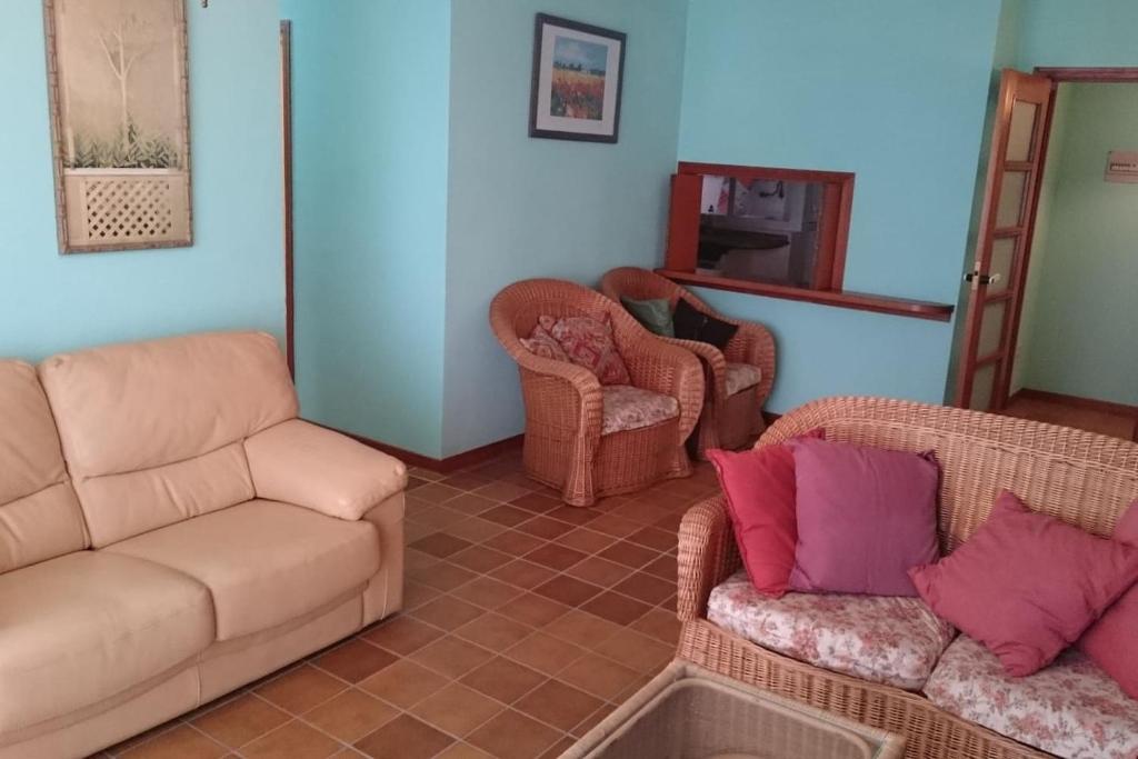 een woonkamer met 2 banken en 2 stoelen bij se alquila piso céntrico en Sanxenxo c/garaje in Sanxenxo