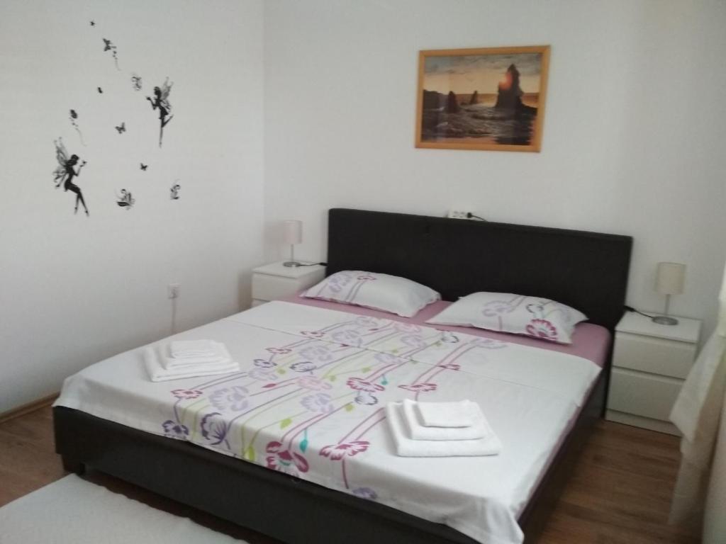 1 dormitorio con 1 cama con sábanas blancas y toallas en Apartman Felice, en Kraljevica