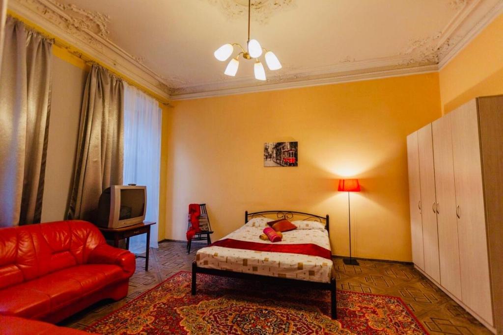 リヴィウにあるLvivskiy Zatyshok TWO Bedrooms ISOLATED with Balconyのベッドルーム(ベッド1台、ソファ、テレビ付)