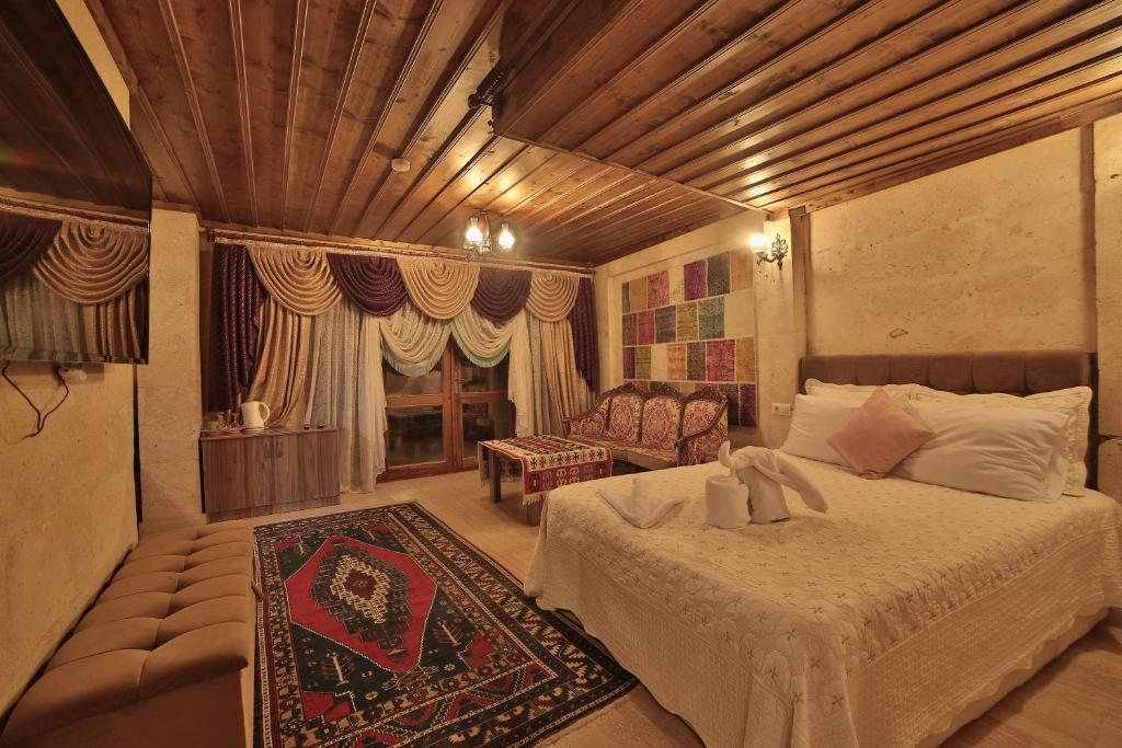 sypialnia z łóżkiem i kanapą w pokoju w obiekcie Goreme Cave Rooms&Spa w Göreme