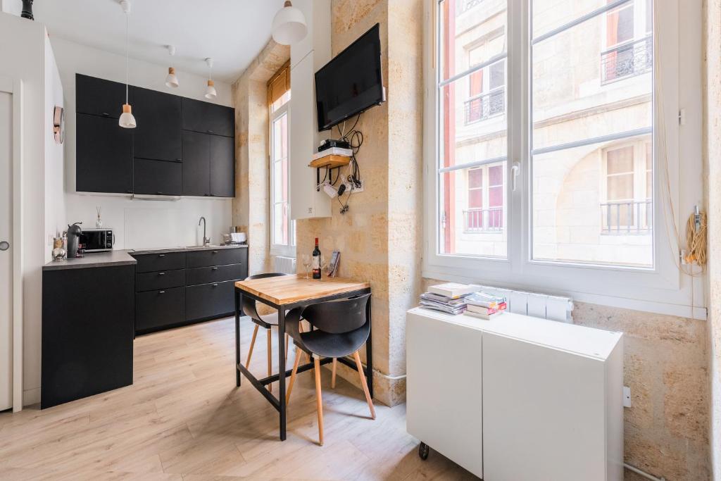 Il comprend une cuisine avec une table en bois et un bureau. dans l'établissement Le COSY - Rue Ausone, à Bordeaux