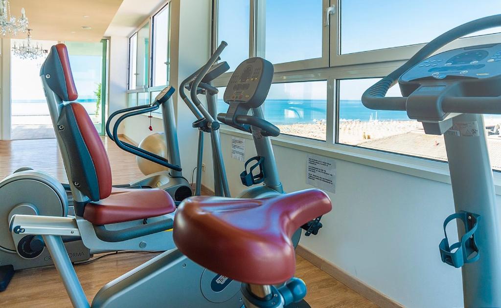 a gym with two exercise bikes in a gym at Hotel Montecarlo in Bibione