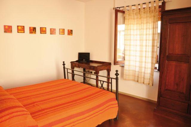sypialnia z łóżkiem, biurkiem i oknem w obiekcie Lanita B&B w mieście Cabras