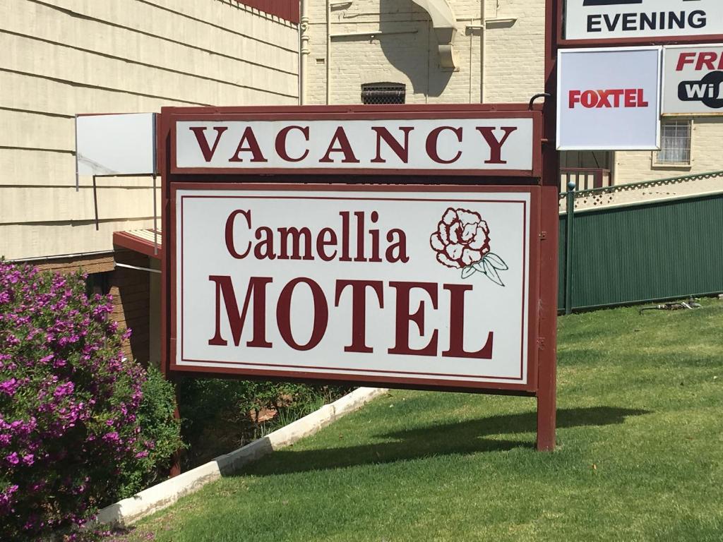 una señal para un motel frente a una casa en Camellia Motel en Narrandera