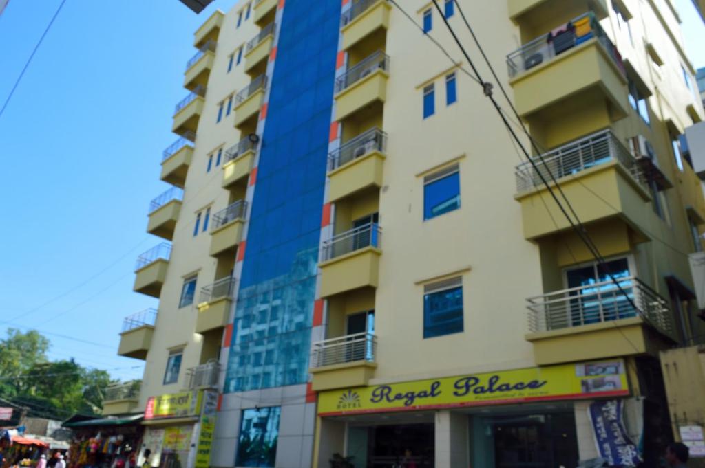a tall yellow building with a sign on it at Hotel Regal Palace in Cox's Bazar