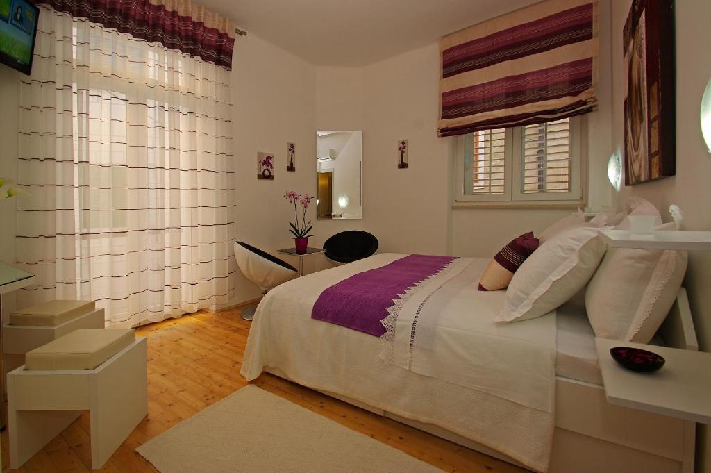 een slaapkamer met een groot wit bed en een raam bij B&B Vela Luka in Vela Luka
