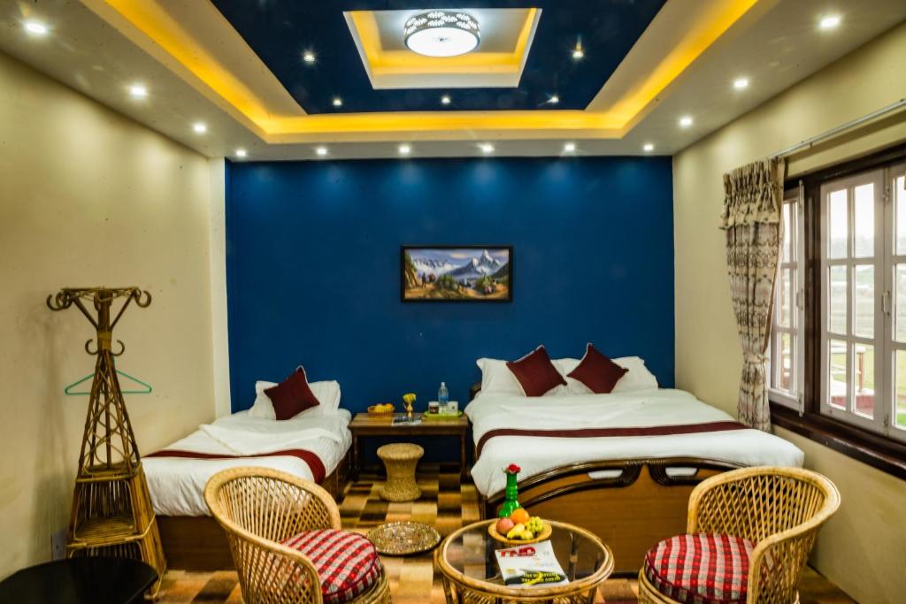 1 dormitorio con 2 camas y pared azul en Homestay Nepal, en Kirtipur