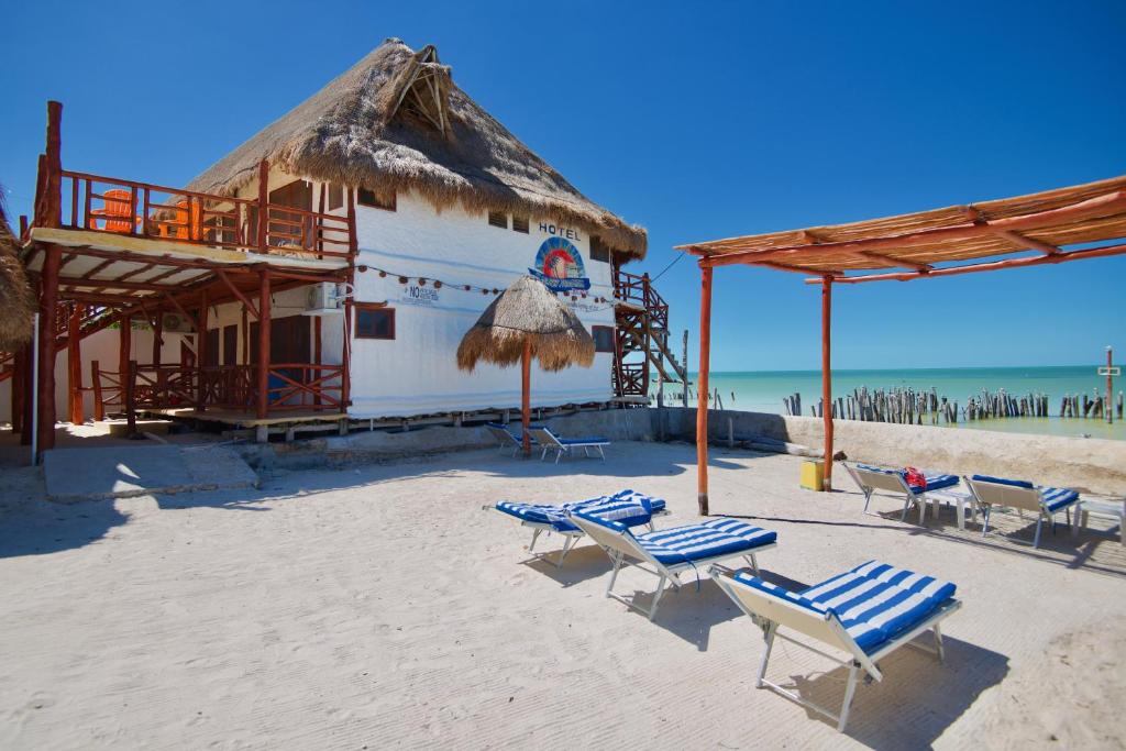 a beach with chairs and a building on the beach at Golden Paradise Beach in Holbox Island