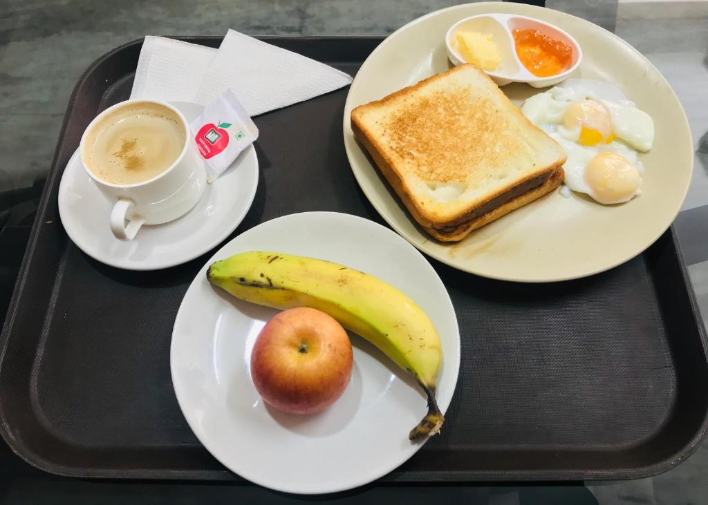 加德满都Hotel Lapha的托盘,包括两盘早餐食品和香蕉