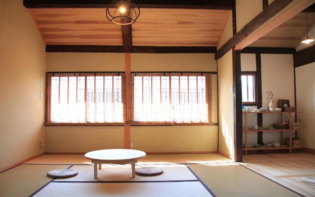 a room with a table and a large window at Temari Inn Yukikai in Kurashiki