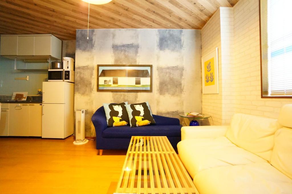 ein Wohnzimmer mit einem Sofa und einem Tisch in der Unterkunft Tomato Takayama Station in Takayama
