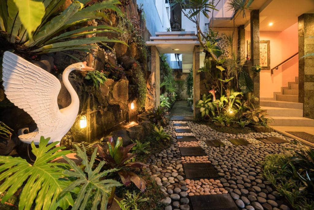 a garden with a swan statue in a building at Griya Tunjung Sari in Denpasar