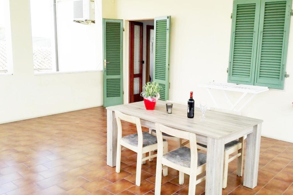een tafel met 2 stoelen en een fles wijn bij la terrazza del silenzio in Fattoria Spedaletto