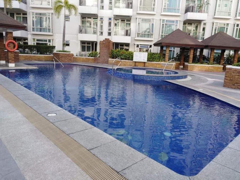 een groot blauw zwembad voor een gebouw bij Ameer Condotel @ Parkside Villa in Manilla