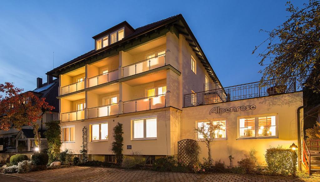 ein großes weißes Gebäude mit vielen Fenstern in der Unterkunft Wohlfühlhotel Alpenrose in Bad Wörishofen