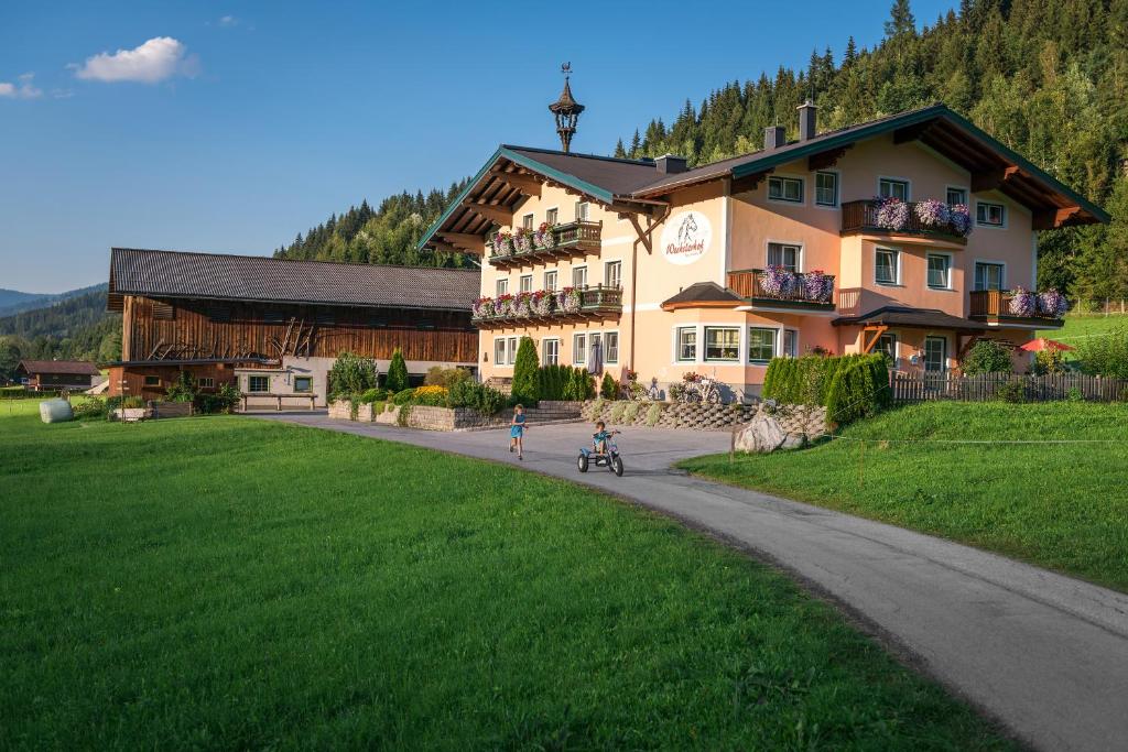 a man riding a bike in front of a building at Wechslerhof in Flachau