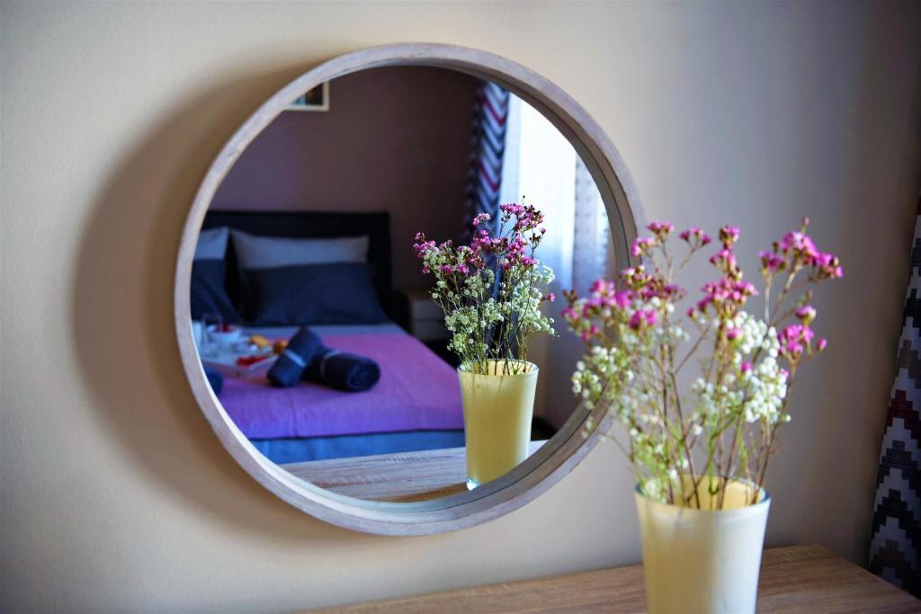 uno specchio con due vasi e fiori su un tavolo di Kampielo Apartment a Città di Corfù