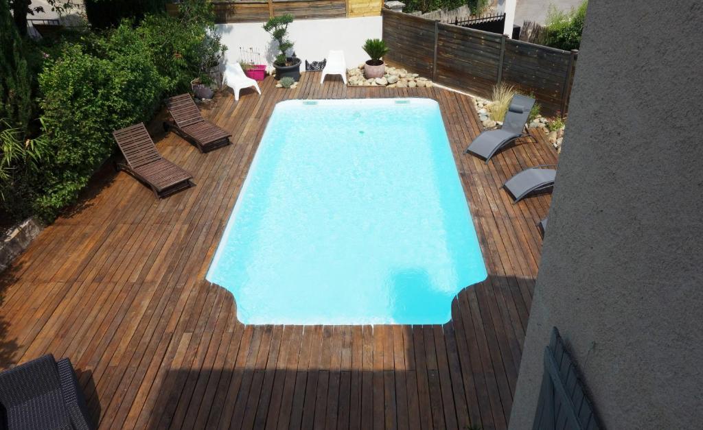 - une piscine sur une terrasse en bois avec des chaises dans l'établissement Villa Pont de l'Arc à Aix avec PISCINE au calme 92 m2, à Aix-en-Provence