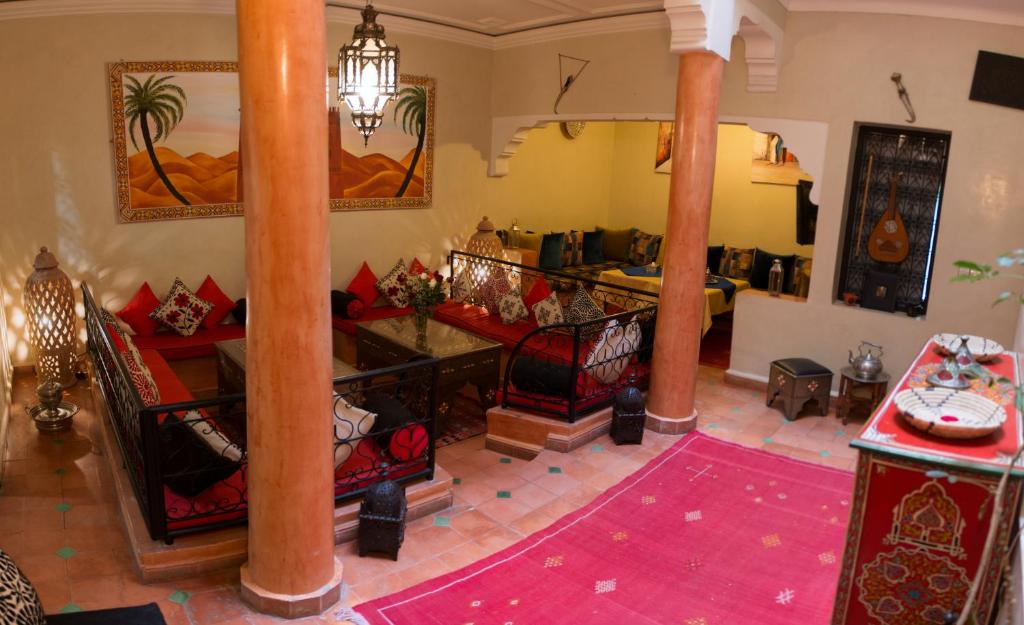 un salon avec colonnes et une chambre avec table dans l'établissement Dar Asdika, à Marrakech