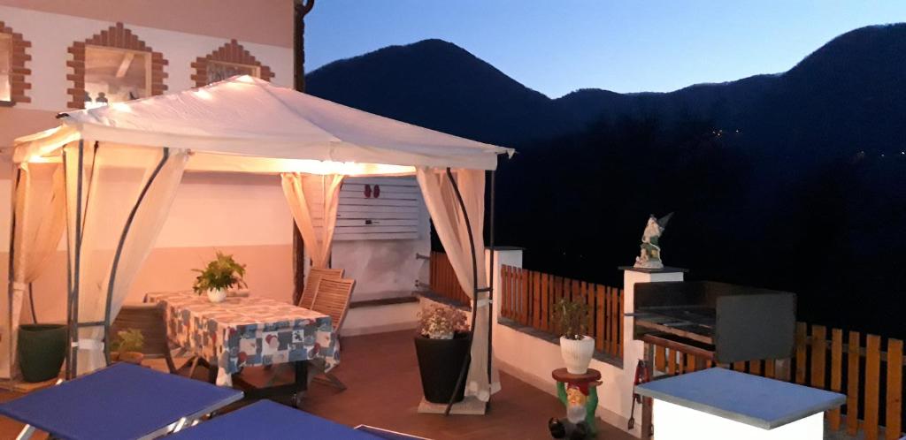 a patio with a table and a white canopy at Il Debbio in Riccò del Golfo di Spezia