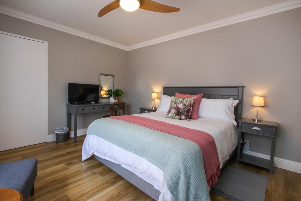 een slaapkamer met een bed en een plafondventilator bij Brookshill - Protea suite in Somerset West